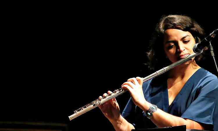 Marcela Nunes toca flauta durante show
