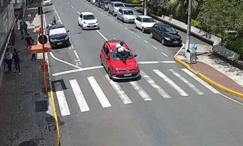 Motociclista disse que estava desatento na hora do acidente(foto: Reprodução) Motociclista em cima do carro vermelho
