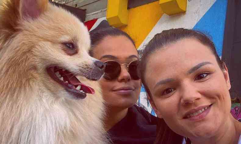 Duas mulheres posam para selfie com um cachorro da raa spitz alemo