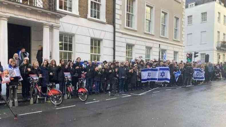 Pessoas com bandeiras de Israel em frente a um prdio londrino