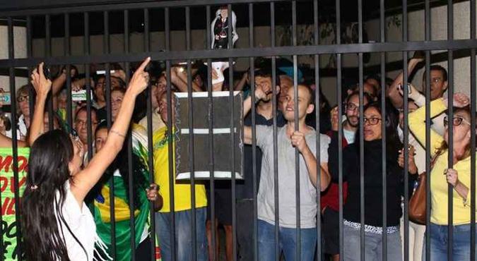 Manifestantes gritam no porto da garagem de bloco onde Dirceu mora agora; cerca de 20 pessoas invadiram o local na chegada do petista(foto: Luiz Nova/Esp. CB/D.A Press)