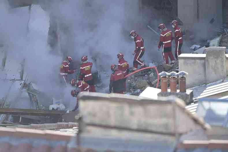 Bombeiros trabalham nos escombros do prdio que desabou, atrs de sobreviventes