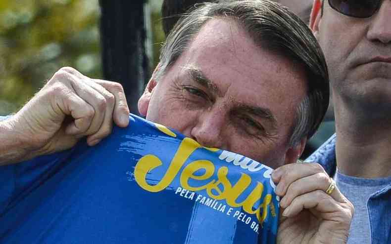 Presidente da Republica, Jair Bolsonaro, beijando a camisa com o escrito Jesus 