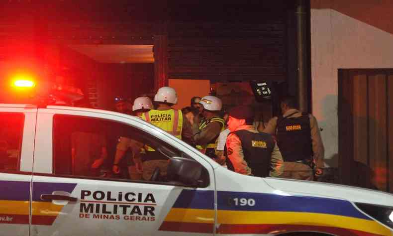 Viatura da Polcia Militar de Minas Gerais com agentes ao lado