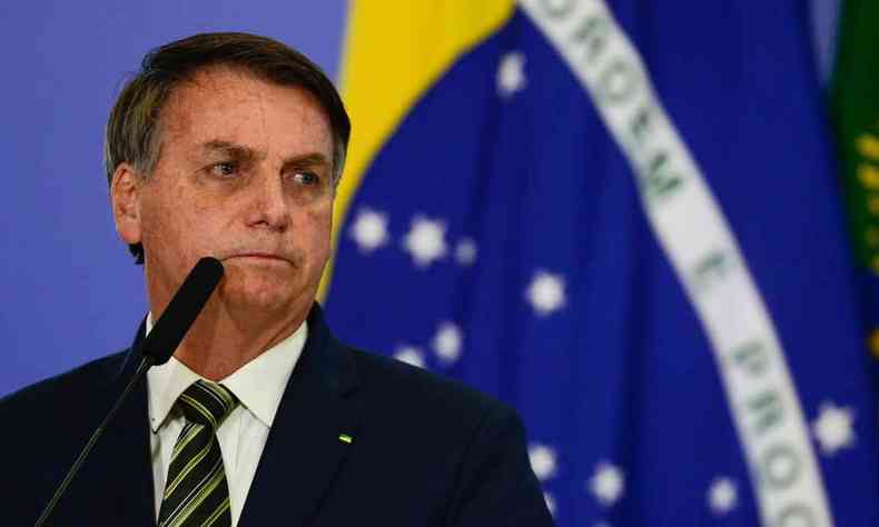 Presidente da Repblica Jair Messias Bolsonaro a esquerda com bandeira do Brasil ao fundo