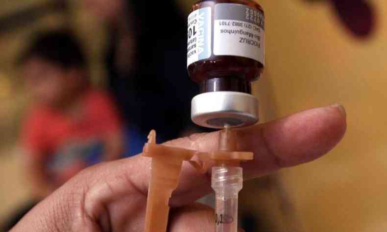 Frasco de vacina com seringa na mo de enfermeira