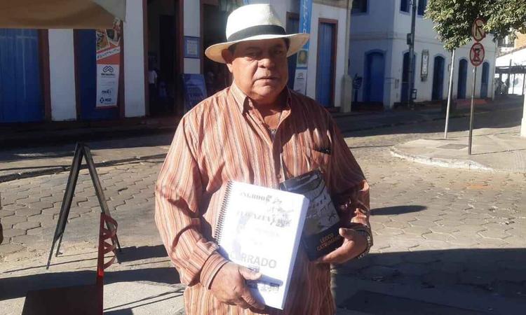 To Azevedo segura dois livros em frente ao Museu Regional do Norte de Minas, em Montes Claros