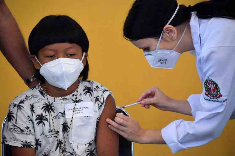 O menino indgena brasileiro Davi Xavante - a primeira criana no Brasil a ser vacinado contra a covid-19 - recebe a primeira dose da vacina Pfizer-BioNTech no hospital Clinicas em So Paulo, Brasil, em 14 de janeiro de 2022. 