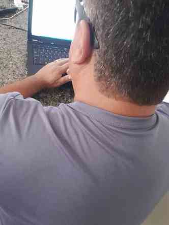 Foto de homem de costas diante de um notebook