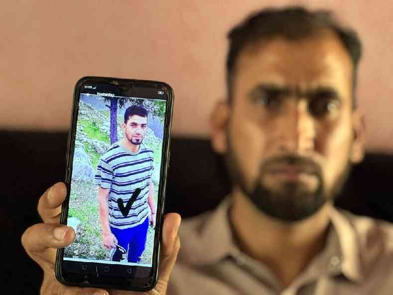 Paquistans Waheed mostra a foto do irmo Mohammad Imran, que est entre os desaparecidos do barco que naufragou perto da costa grega