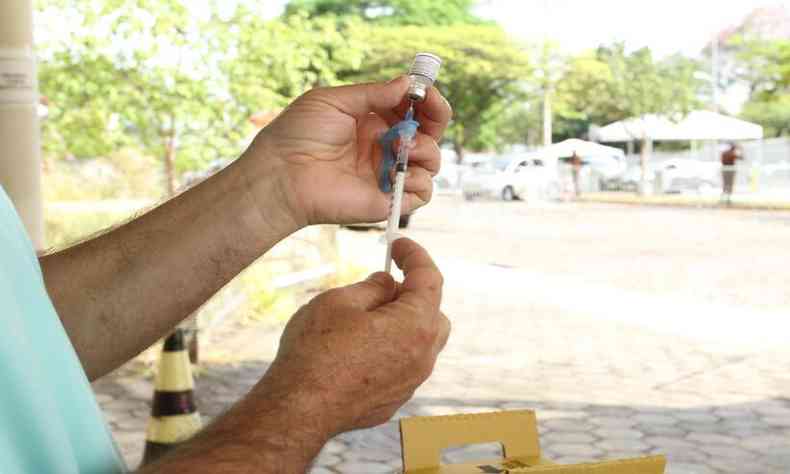 Profissional de sade prepara a seringa para aplicao do imunizante 