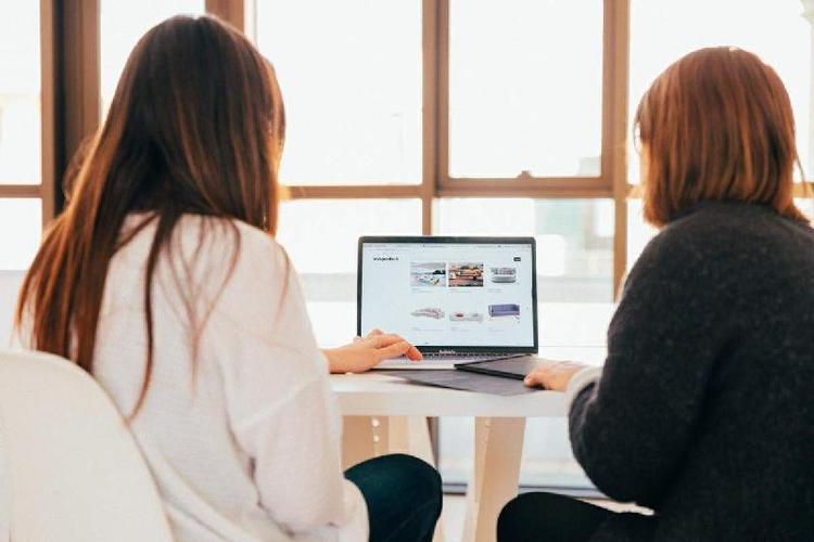 Mulheres sentadas trabalhando por meio do computador