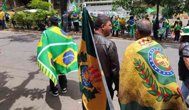 Dois homens com bandeiras do Império do Brasil.