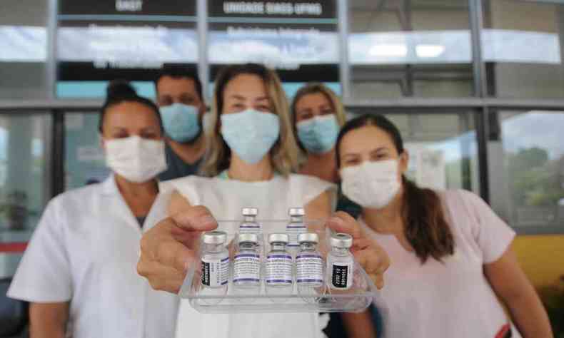 Equipe de enfermeiros segurando a vacina da Pfizer
