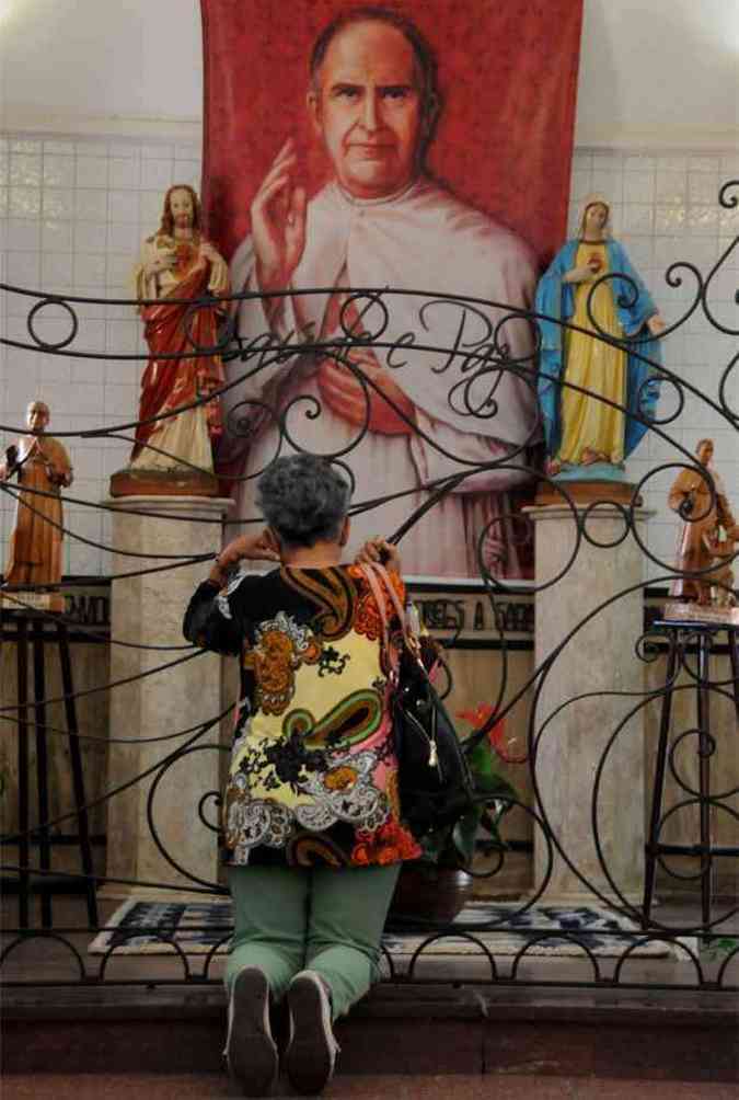 Mulher reza e pede uma graa diante da imagem de Padre Eustquio (foto: Beto Novaes/EM/D.A Press)