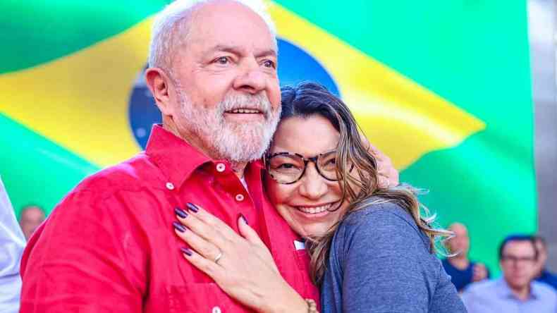 Lula e Janja abraados com a bandeira do Brasil atrs