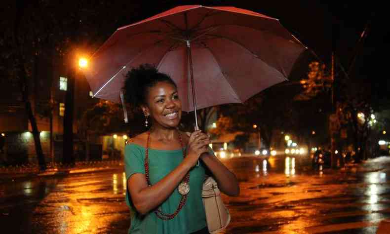 A educadora fsica Adriana Costa se protege da chuva com uma sombrinha(foto: Tlio Santos/EM/DA Press)