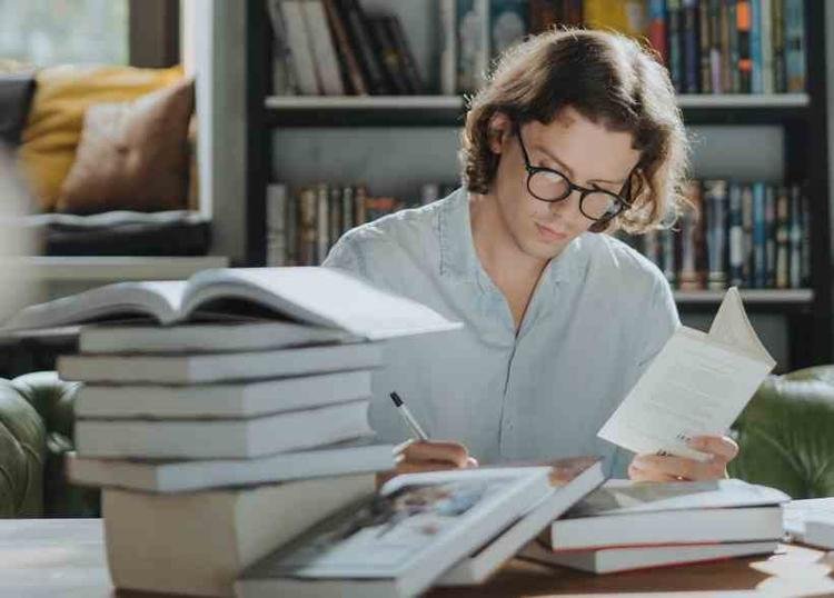Homem de �culos estudando