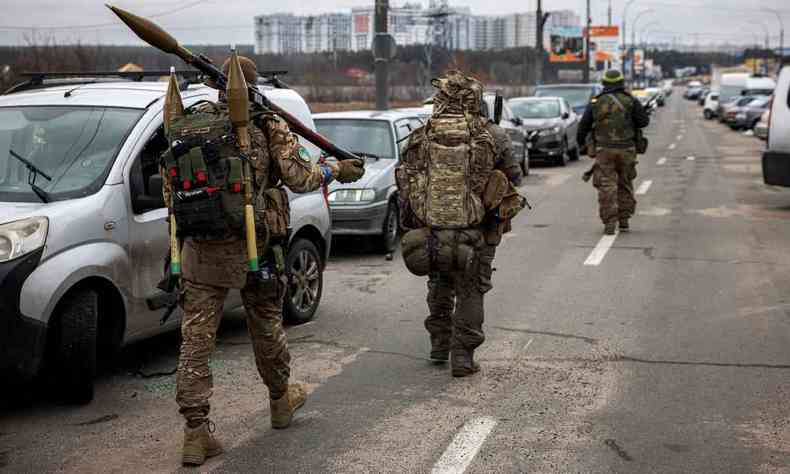 Militares ucranianos carregam granadas e rifles de preciso enquanto caminham em direo  cidade de Irpin, a noroeste de Kiev, em 13 de maro de 2022