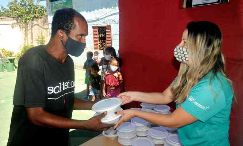 Entrega de marmitas na Vila Mariquinhas, na capital, onde pessoas de todas as idades se organizam para receber as doaes (foto: LEANDRO COURI/EM/D.A PRESS)