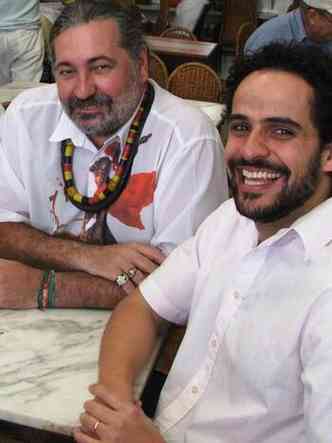 Moacyr Luz e Dudu Niccio, sentados na mesa de bar, sorriem para cmara