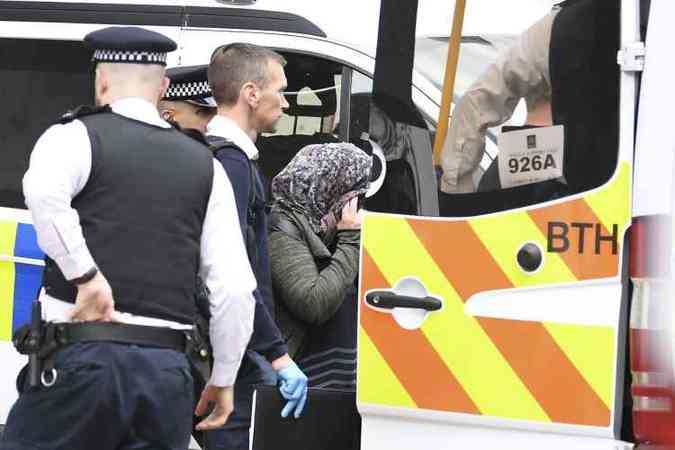 Foras de segurana realizaram vrias buscas no distrito de Barking, a cerca de 14 quilmetros de Londres. Na foto. mulher  levada pela polcia (foto: Justin Tallis/AFP)