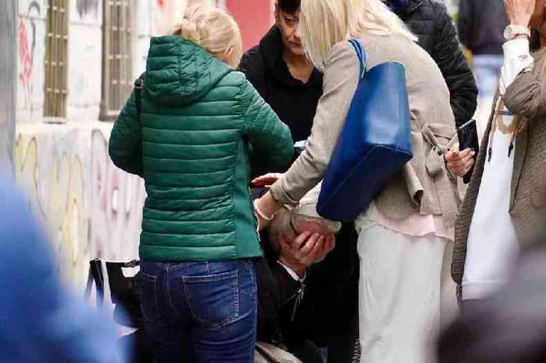 Pais e parentes de luto em frente  escola no centro de Belgrado