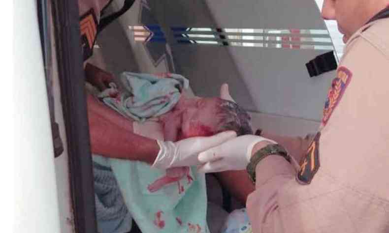 Sargento Aguiar e soldado Sandro amparam o pequeno Nick, que nasceu dentro de uma ambulncia neste domingo(foto: Polcia Militar/Divulgao)