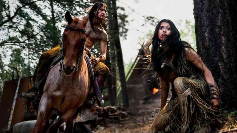 Atores Dane DiLiegro, em cima de um cavalo, e Amber Midthunder, como a ndia Naru, em cena do filme O Predador: A caada