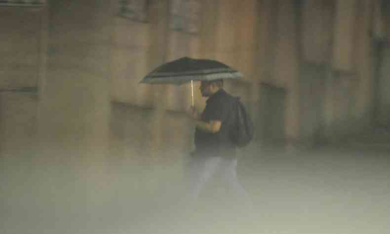 Homem com guarda chuvas aberto