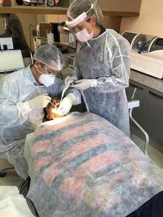 O cirurgio-dentista Cristiano Campos Nunes e a auxiliar de sade bucal (ASB) Geralda das Graas de Matos atendem paciente seguindo os protocolos de segurana