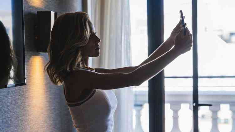 Mulher com braos esticados tirando selfie