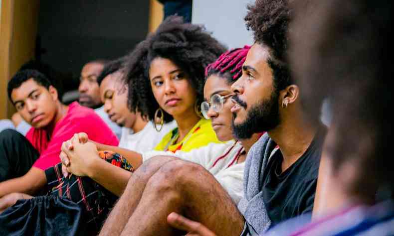 Foto do evento em 2019. Há uma fileira de jovens negros sentados enquanto conversam