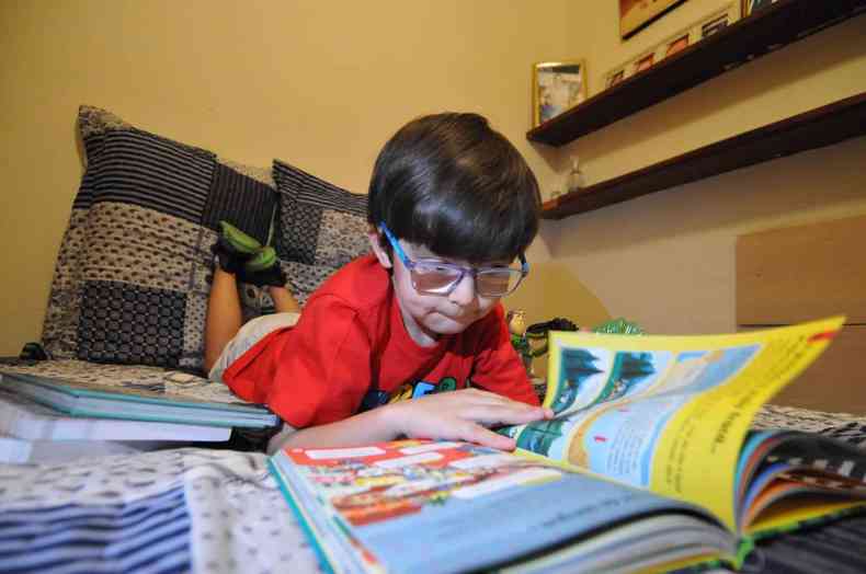 O menino Isaac lendo um livro
