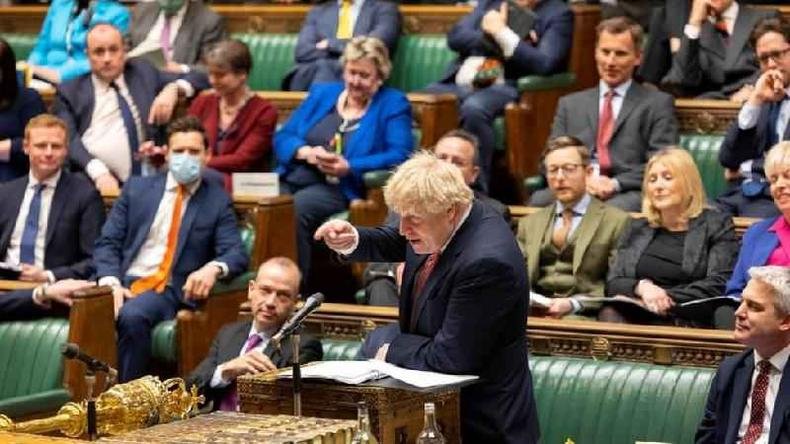 'Depois de dois dos anos mais sombrios e cruéis de nossa história em tempos pacíficos, acredito que este é um momento de orgulho', comemorou Johnson ao anunciar relaxamento nas medidas contra a covid-19(foto: UK Parliament via Reuters) Johnson gesticula enquanto discursa, rodeado por parlamentares sentados