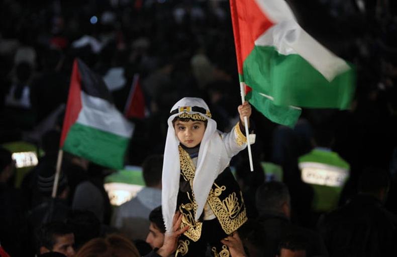 Palestinos celebram a decis�o da ONU em Ramallah. Apesar da oposi��o dos EUA e de Israel, a Assembleia Geral aprovou o status de Estado observador (foto: AFP PHOTO / ABBAS MOMANI )