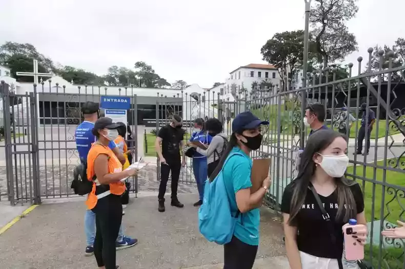 Imagem mostra estudantes na porta de universidade