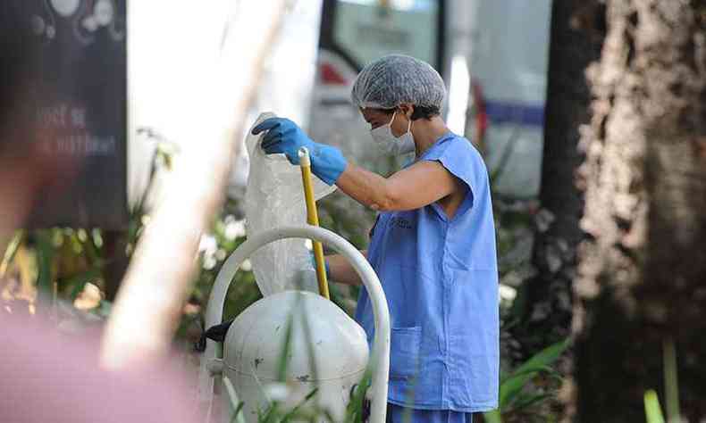 Funcionária limpa lixeira na Santa Casa de BH. Atividades essenciais para higienizar ambientes de combate à pandemia sofrem mais com a doença(foto: Leandro Couri/EM/D.A Press)