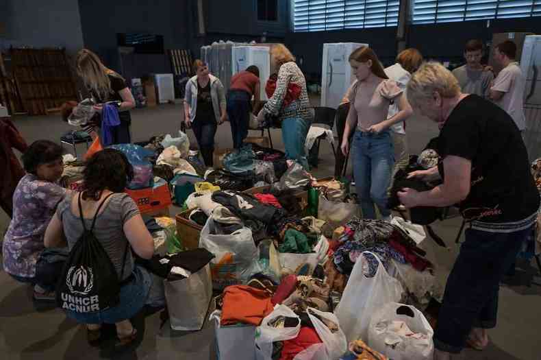 Refugiados ucranianos escolhem roupas doadas em igreja