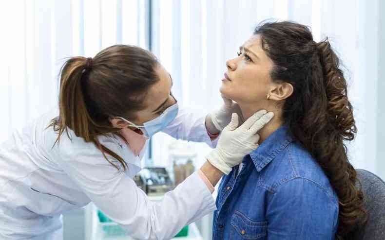 Endocrinologista examinando a garganta de uma jovem 