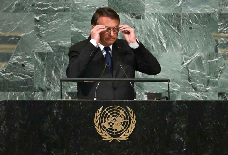 Presidente Jair Bolsonaro pe os culos para discursar na sede da ONU, em Nova York