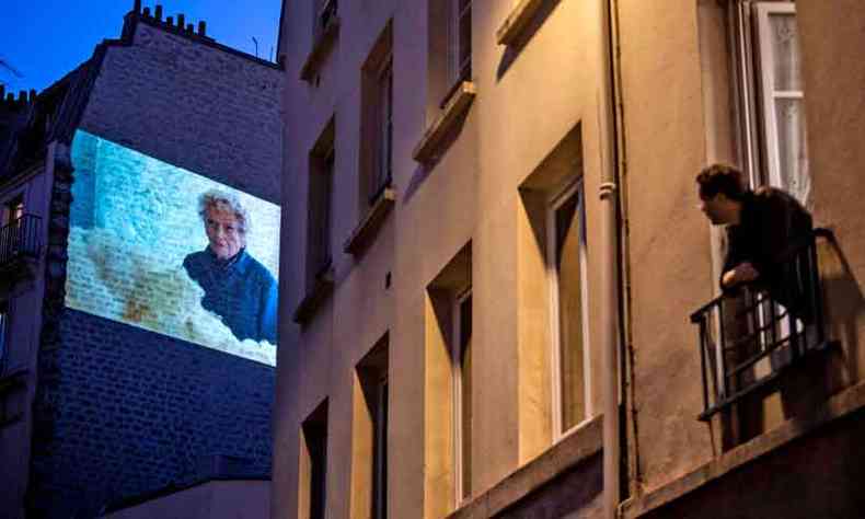 Morador de Paris assiste a filme projetado em fachada de prdio, na sexta passada, quando pas completou 46 dias de quarentena. Total de mortes na Frana chega a 25 mil(foto: Martin Bureau/AFP)