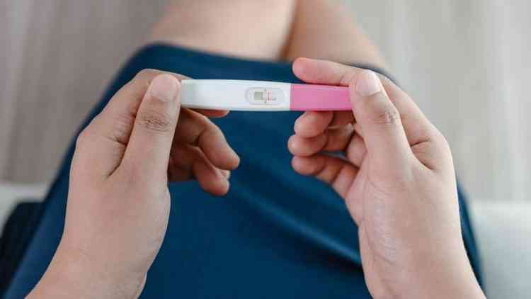 Mulher com exame de gravidez nas mos