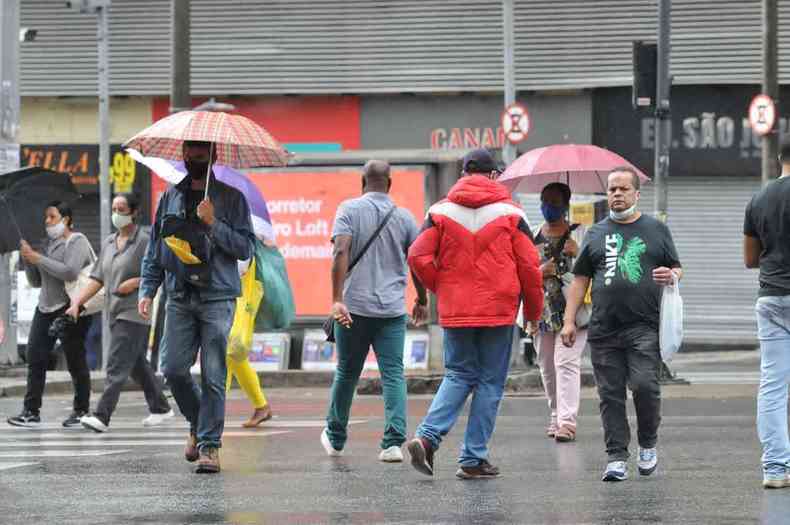 Pedestres com guarda-chuvas na Avenida Afonso Pena, em BH 