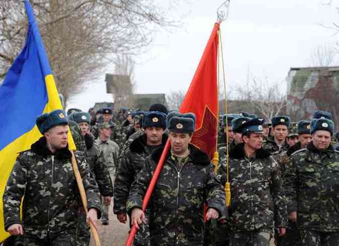 Pilotos ucranianos marcham na base area de Belbek. Tropas russas disparam tiros de advertncia prximo  base na noite desta tera-feira(foto: VIKTOR DRACHEV / AFP)