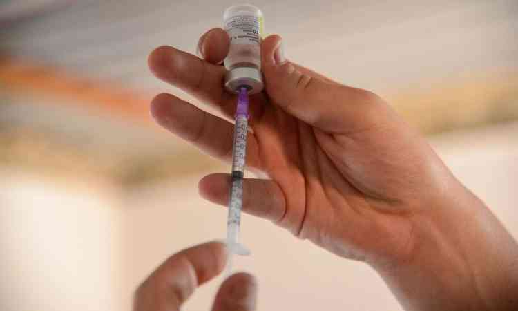 Enfermeiro com agulha e vacina da covid-19