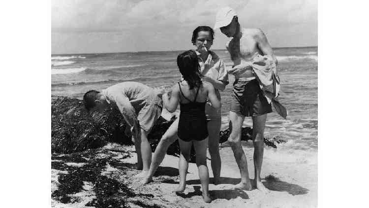 Robert Oppenheimer em momento de descontrao com a famlia na praia em foto em preto e branco