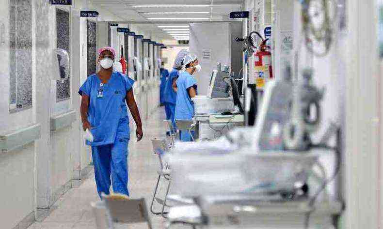 Enfermeiros caminhas por corredor hospital