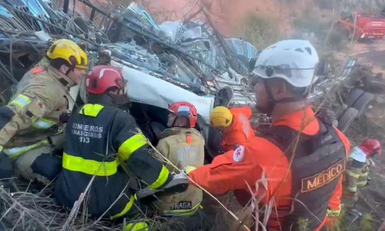 Os bombeiros tiveram dificuldade em retirar o motorista do veículo, já que a cabine ficou destruída (foto: CBMMG/Divulgação ) Equipe do Corpo de Bombeiros faz o resgate do motorista do caminhão
