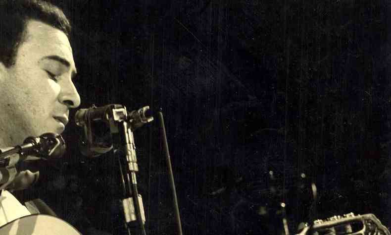 O cantor Joo Gilberto olha para baixo, enquanto toca violo durante um show